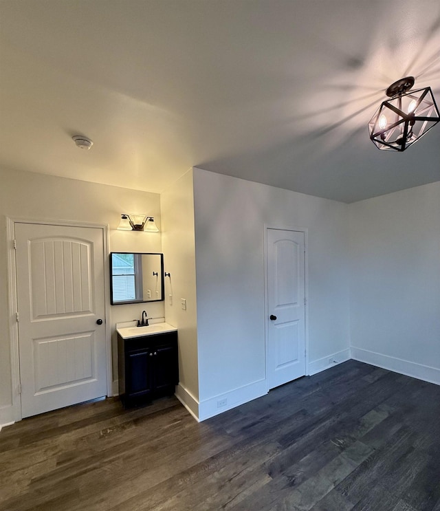 bathroom featuring vanity, wood finished floors, and baseboards