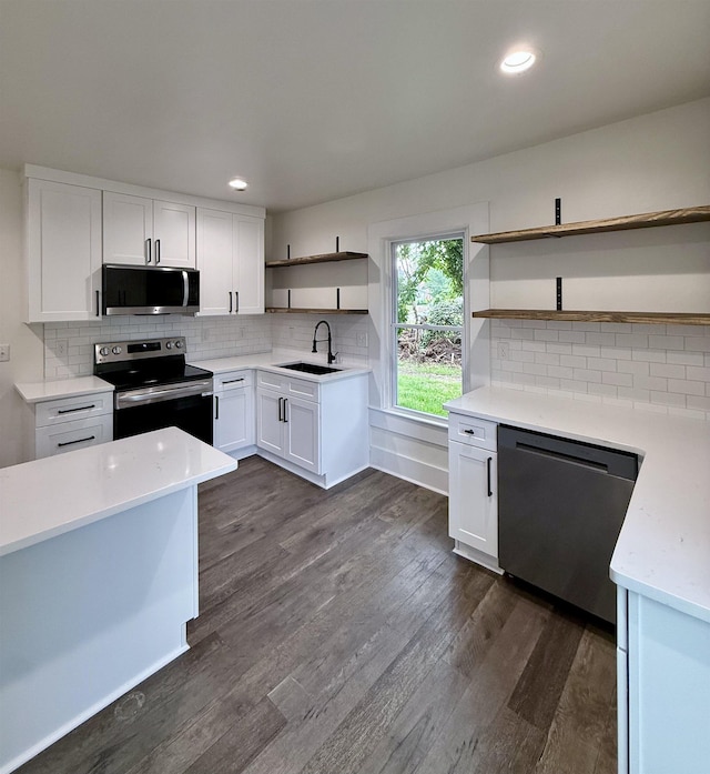 kitchen with stainless steel appliances, open shelves, white cabinets, and a sink