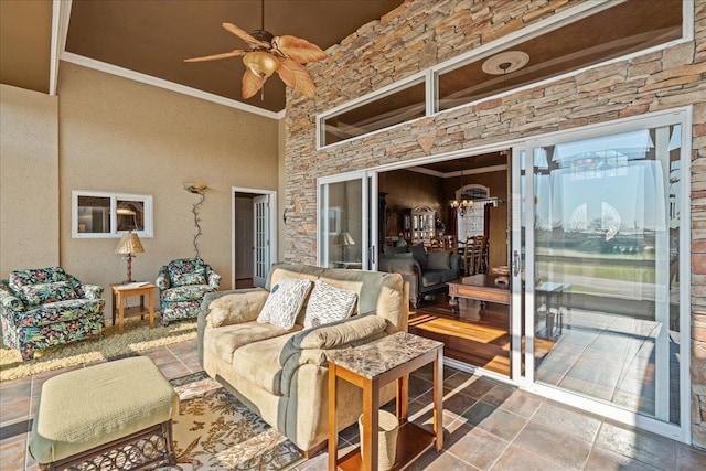 living area with ceiling fan with notable chandelier and crown molding