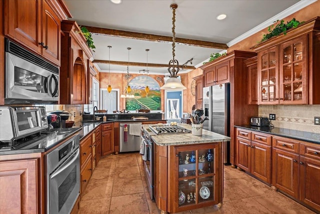 kitchen featuring stainless steel appliances, decorative backsplash, ornamental molding, and a center island
