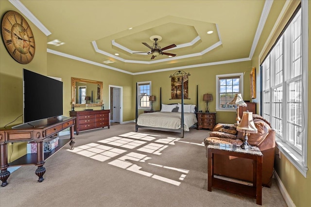 carpeted bedroom with crown molding, a raised ceiling, and baseboards