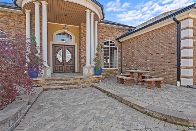 property entrance featuring covered porch and stone siding