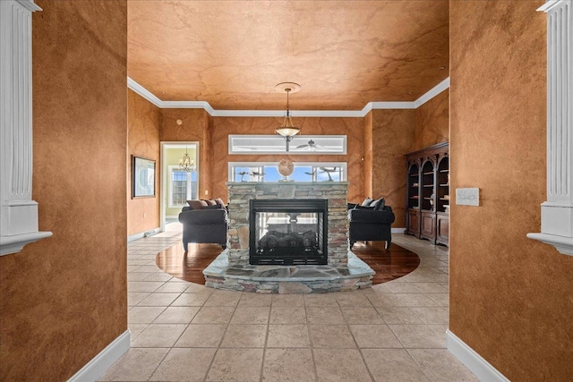 living area featuring baseboards, a stone fireplace, and crown molding
