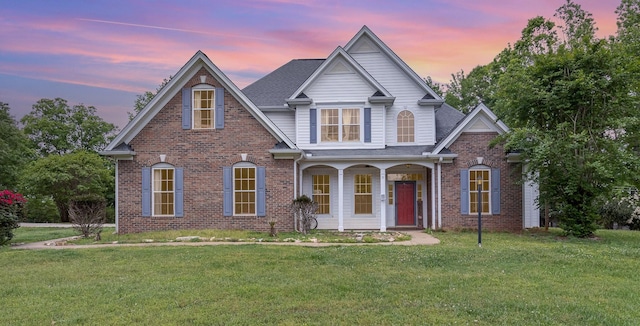 view of front of home featuring a porch, a front yard, and brick siding