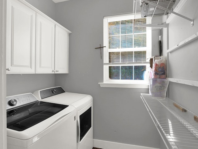laundry room with baseboards, cabinet space, washer and clothes dryer, and plenty of natural light