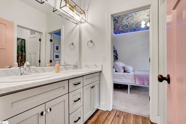 bathroom featuring double vanity, wood finished floors, ensuite bath, and a sink