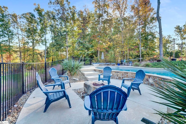 view of patio / terrace with a fire pit, a fenced backyard, and a fenced in pool
