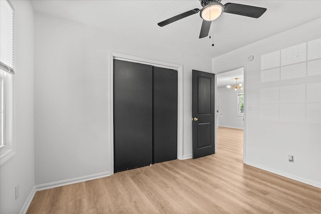 unfurnished bedroom with a closet, light wood-style flooring, and baseboards