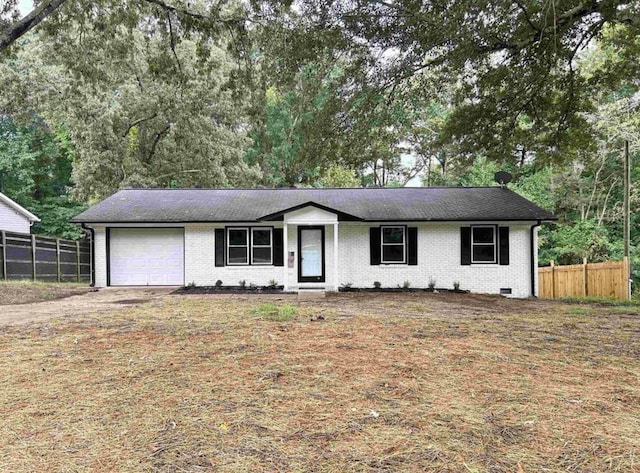 ranch-style house featuring brick siding, driveway, a garage, and fence