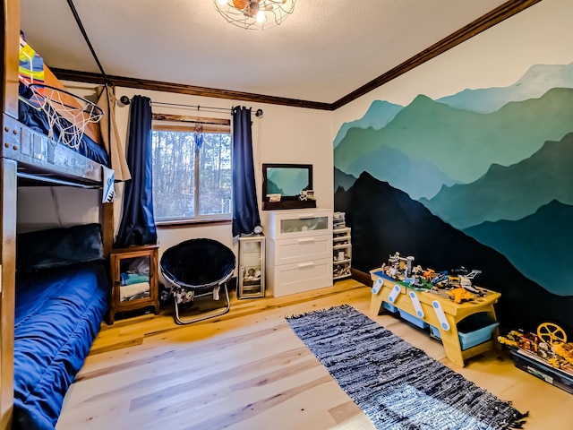 bedroom with ornamental molding and wood finished floors