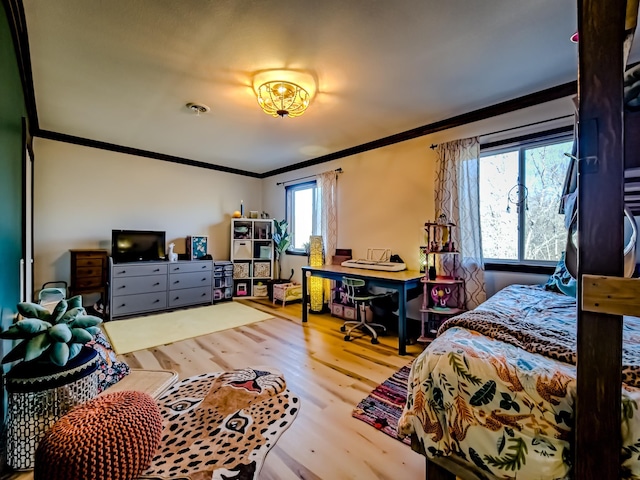 bedroom featuring crown molding and wood finished floors