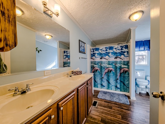 full bath featuring wood finished floors, toilet, ornamental molding, and a sink
