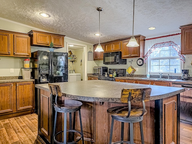 kitchen featuring crown molding, black appliances, a textured ceiling, and light wood-style floors