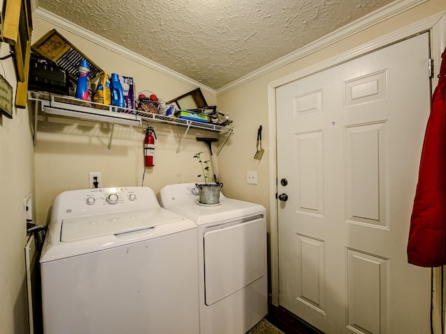 laundry room with a textured ceiling, washing machine and clothes dryer, crown molding, and laundry area