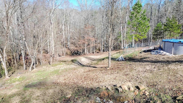 view of yard featuring a forest view and an outdoor pool