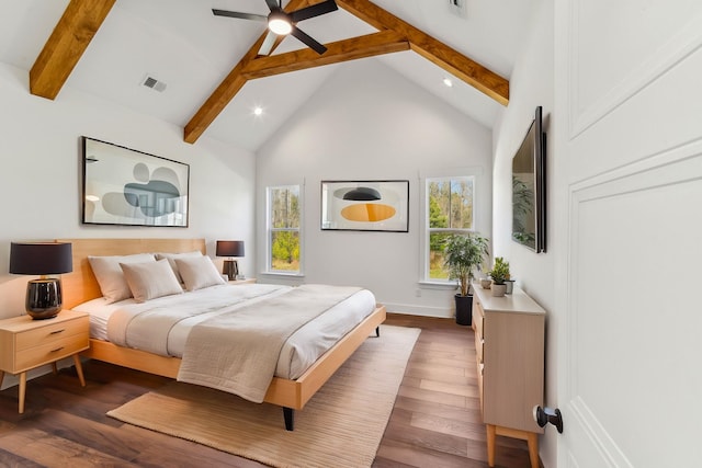bedroom with beamed ceiling, visible vents, multiple windows, and wood-type flooring