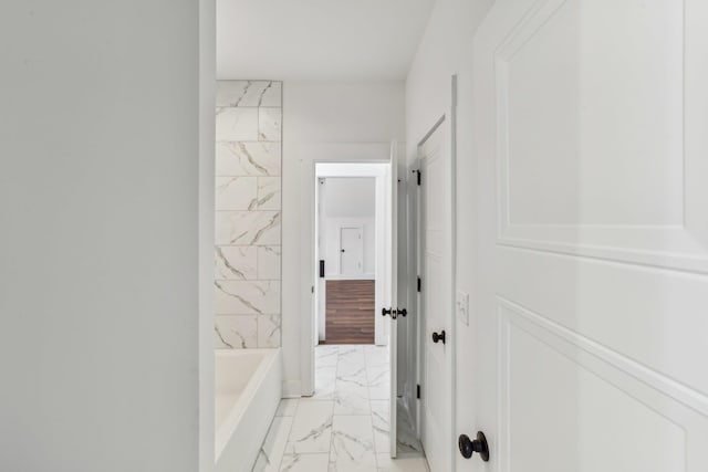 bathroom with a bathtub and marble finish floor