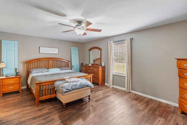 bedroom with a ceiling fan, baseboards, and dark wood finished floors