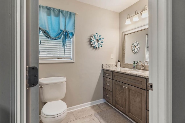 bathroom featuring a healthy amount of sunlight, tile patterned floors, vanity, and toilet