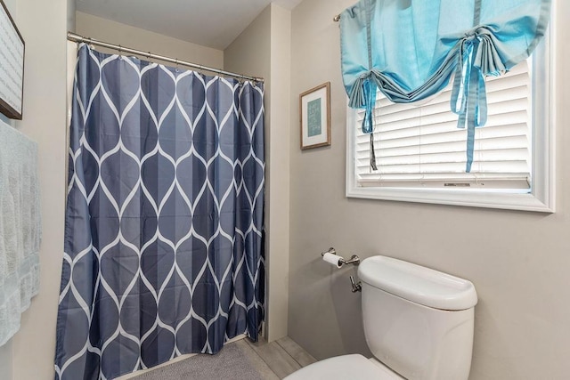 full bath with a shower with curtain and toilet