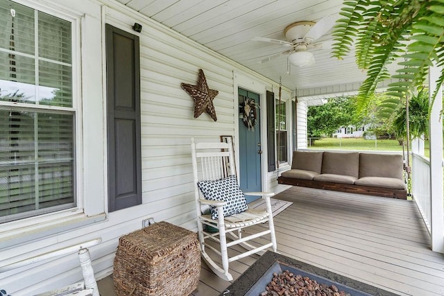 wooden deck with a porch and a ceiling fan