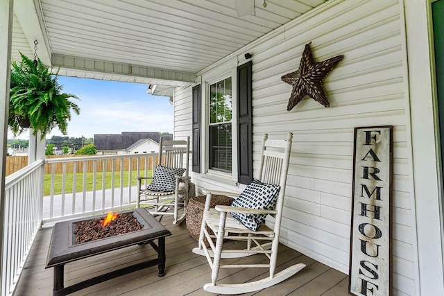 deck with a porch and a fire pit