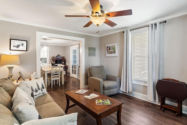 living area featuring crown molding, baseboards, a ceiling fan, and dark wood finished floors