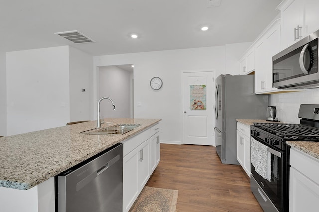kitchen with visible vents, a sink, stainless steel appliances, white cabinetry, and dark wood-type flooring