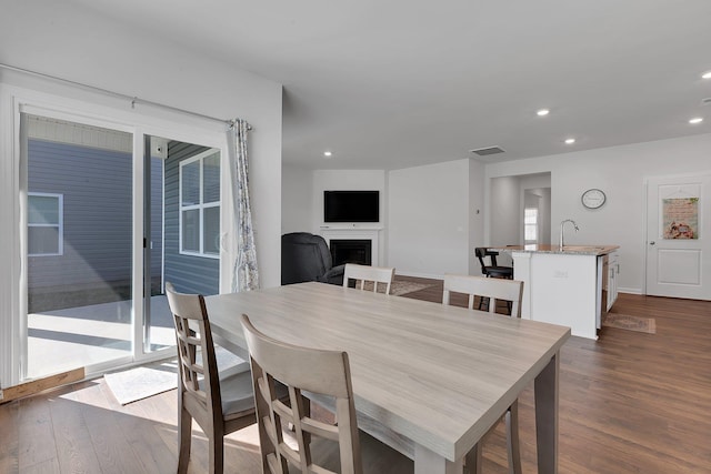 dining space featuring recessed lighting, a fireplace, dark wood finished floors, and visible vents