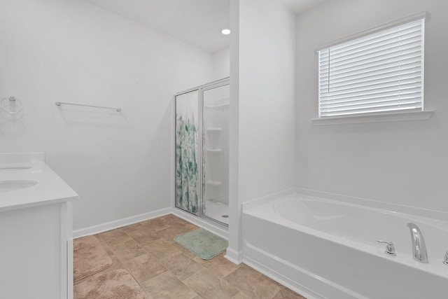 bathroom featuring baseboards, a shower stall, a garden tub, and stone finish flooring