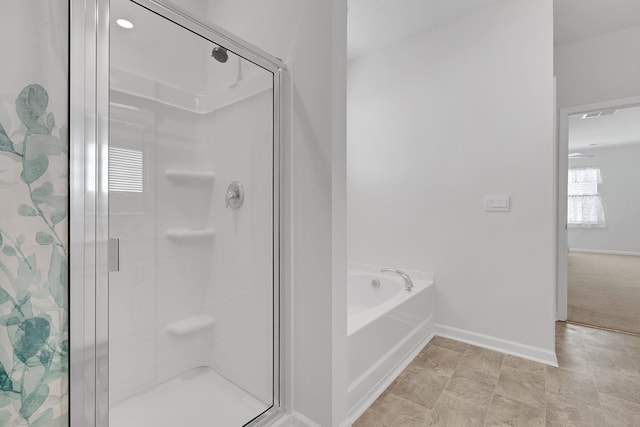 bathroom featuring baseboards, a garden tub, and a shower stall