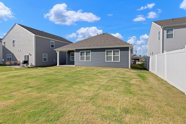 back of house featuring a patio, a lawn, and fence