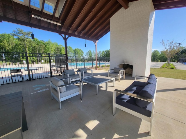 view of patio / terrace featuring a community pool, an outdoor living space with a fireplace, and fence