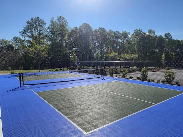 view of tennis court with fence and community basketball court