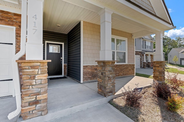 property entrance with covered porch and stone siding