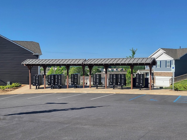 uncovered parking lot featuring fence and mail area