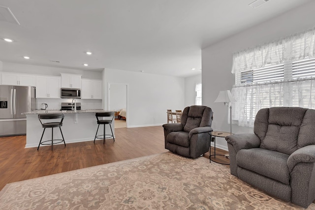 living area featuring recessed lighting, baseboards, visible vents, and dark wood-style floors