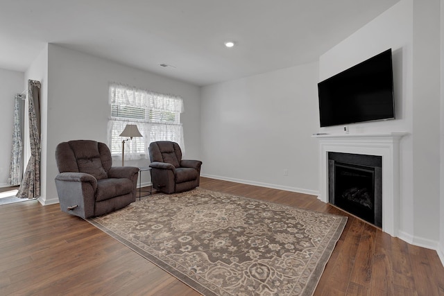 living area with visible vents, a fireplace, wood finished floors, baseboards, and recessed lighting