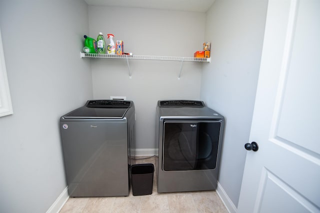 laundry area featuring laundry area, baseboards, and washing machine and clothes dryer