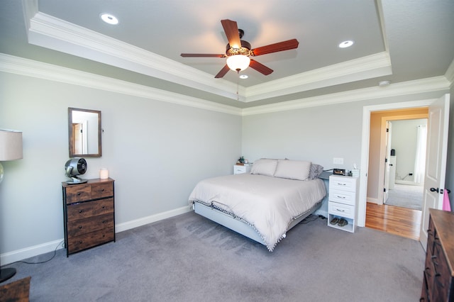 bedroom featuring a raised ceiling, ornamental molding, carpet, and baseboards