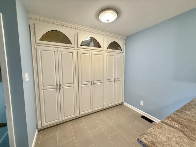 interior space featuring light tile patterned flooring, baseboards, and visible vents