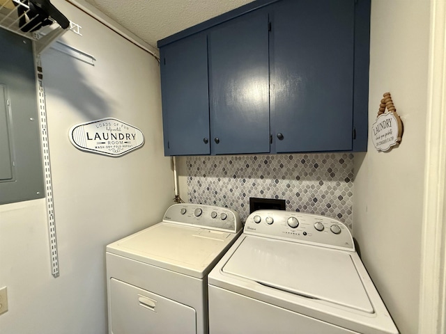 washroom featuring cabinet space, a textured ceiling, and washing machine and clothes dryer