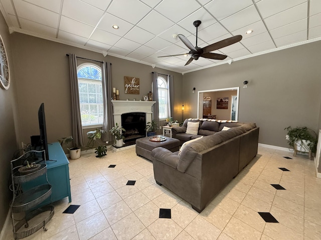 living area featuring plenty of natural light, ornamental molding, a ceiling fan, and light tile patterned flooring