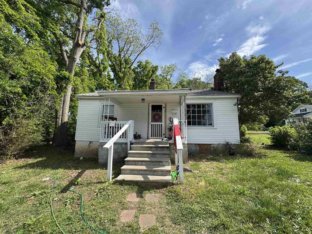 view of front of house featuring covered porch, crawl space, and a chimney