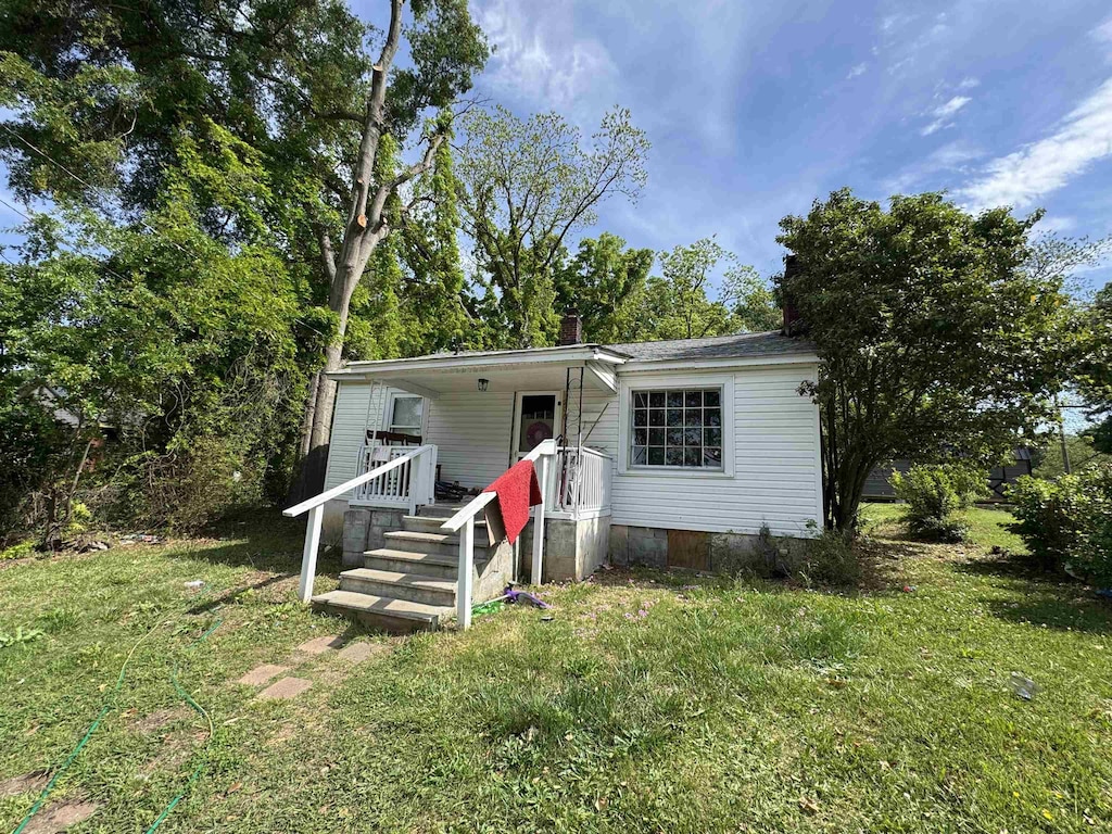 view of front facade featuring a chimney, crawl space, and a front yard