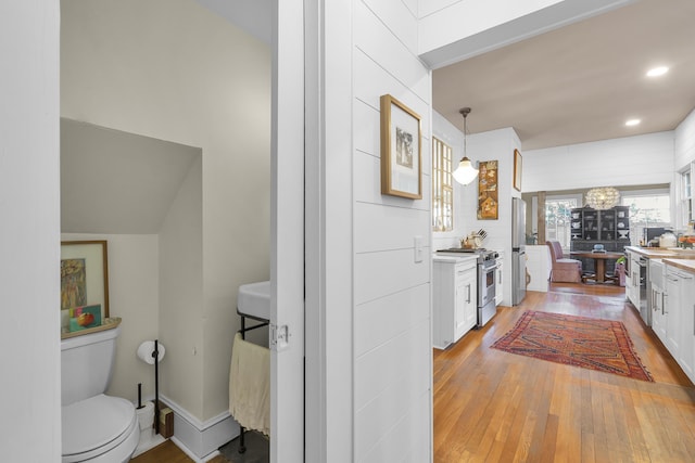 kitchen with light countertops, stainless steel appliances, white cabinetry, and light wood-type flooring
