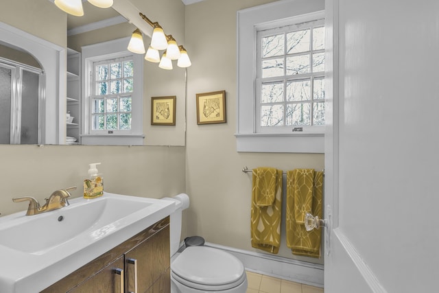 bathroom with crown molding, a shower with shower door, vanity, toilet, and a chandelier