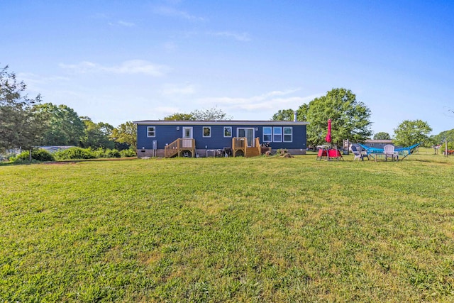 rear view of property featuring a lawn
