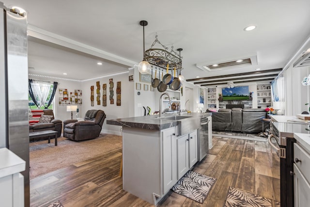 kitchen with recessed lighting, open floor plan, a sink, and dark wood-type flooring