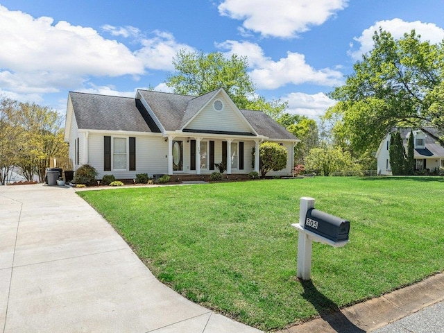 view of front of home with driveway, covered porch, and a front yard
